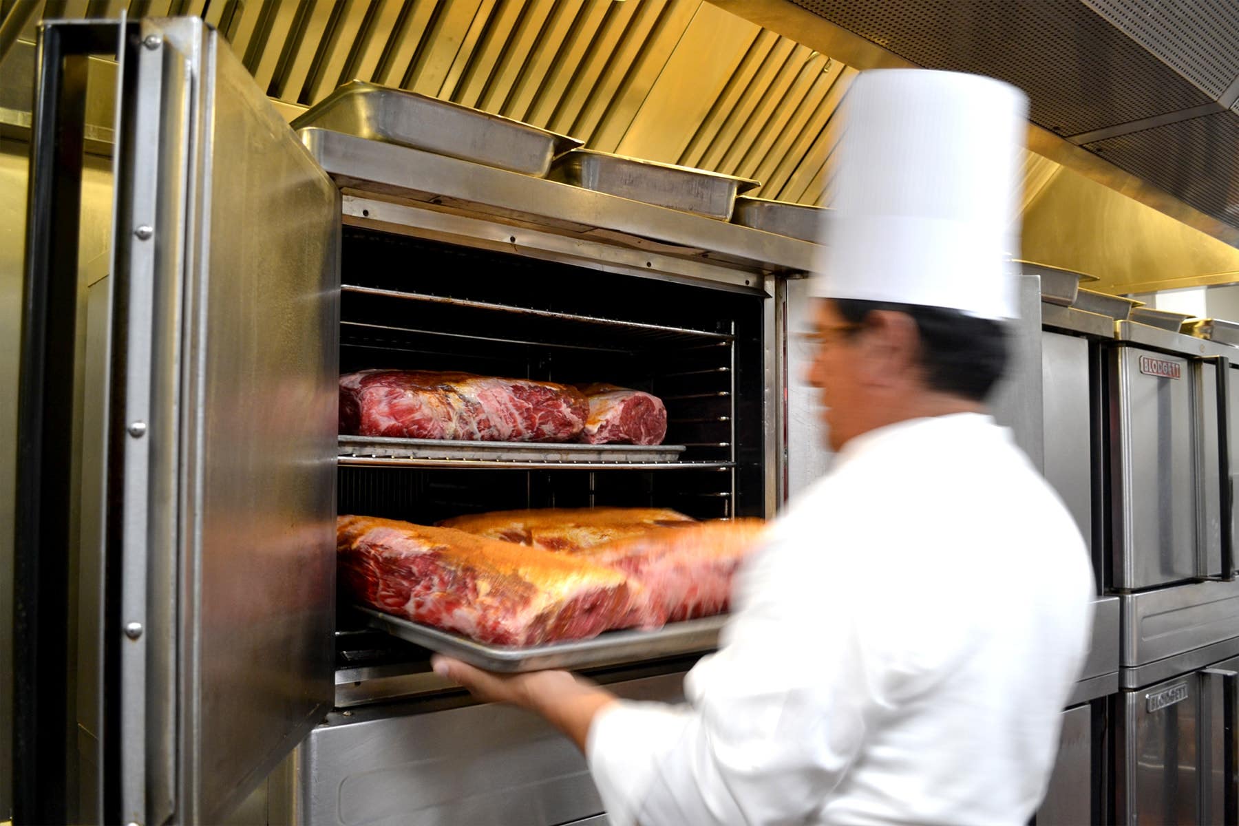 A chef loads prime rib into an oven at Lawry's The Prime Rib