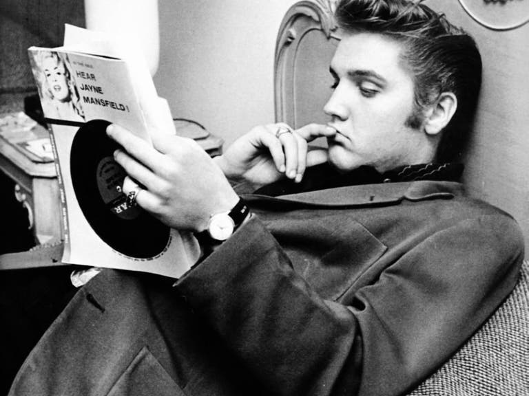 Elvis Presley reads a magazine at The Knickerbocker Hotel on Aug. 18, 1956