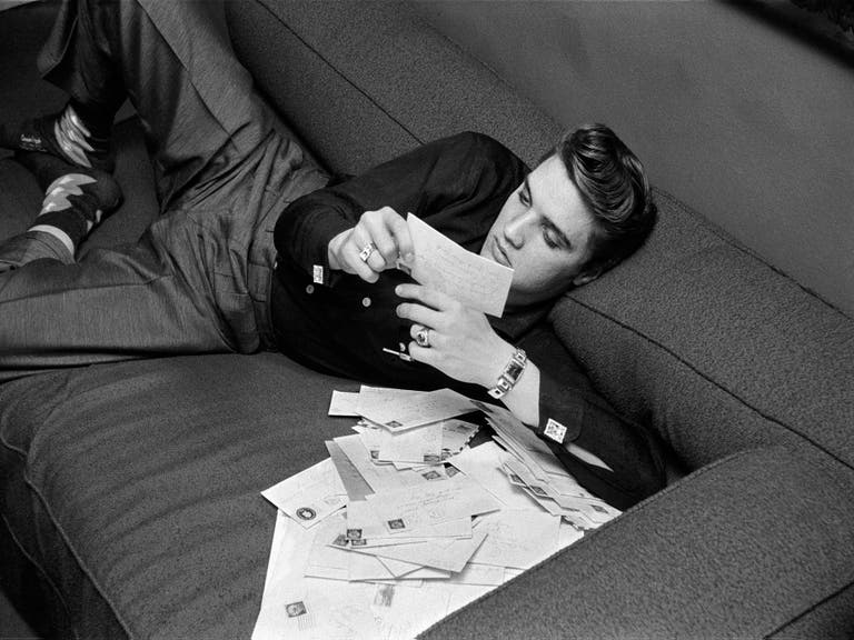Elvis reads fan letters in his suite at the Warwick Hotel in New York City on Mar. 17, 1956