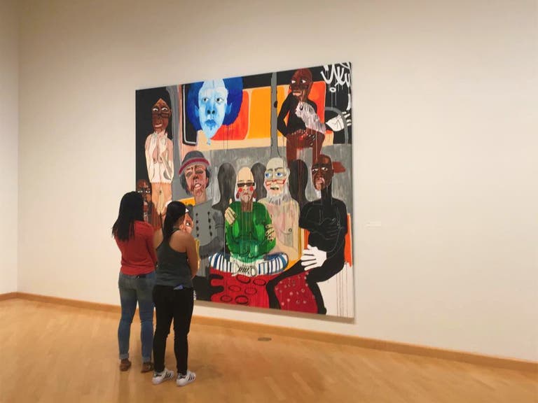 Visitors contemplate a painting at the Museum of African American Art