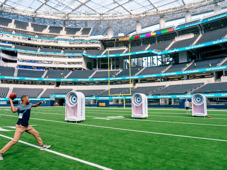 A guest throws a football at targets on the SoFi Stadium Tour.