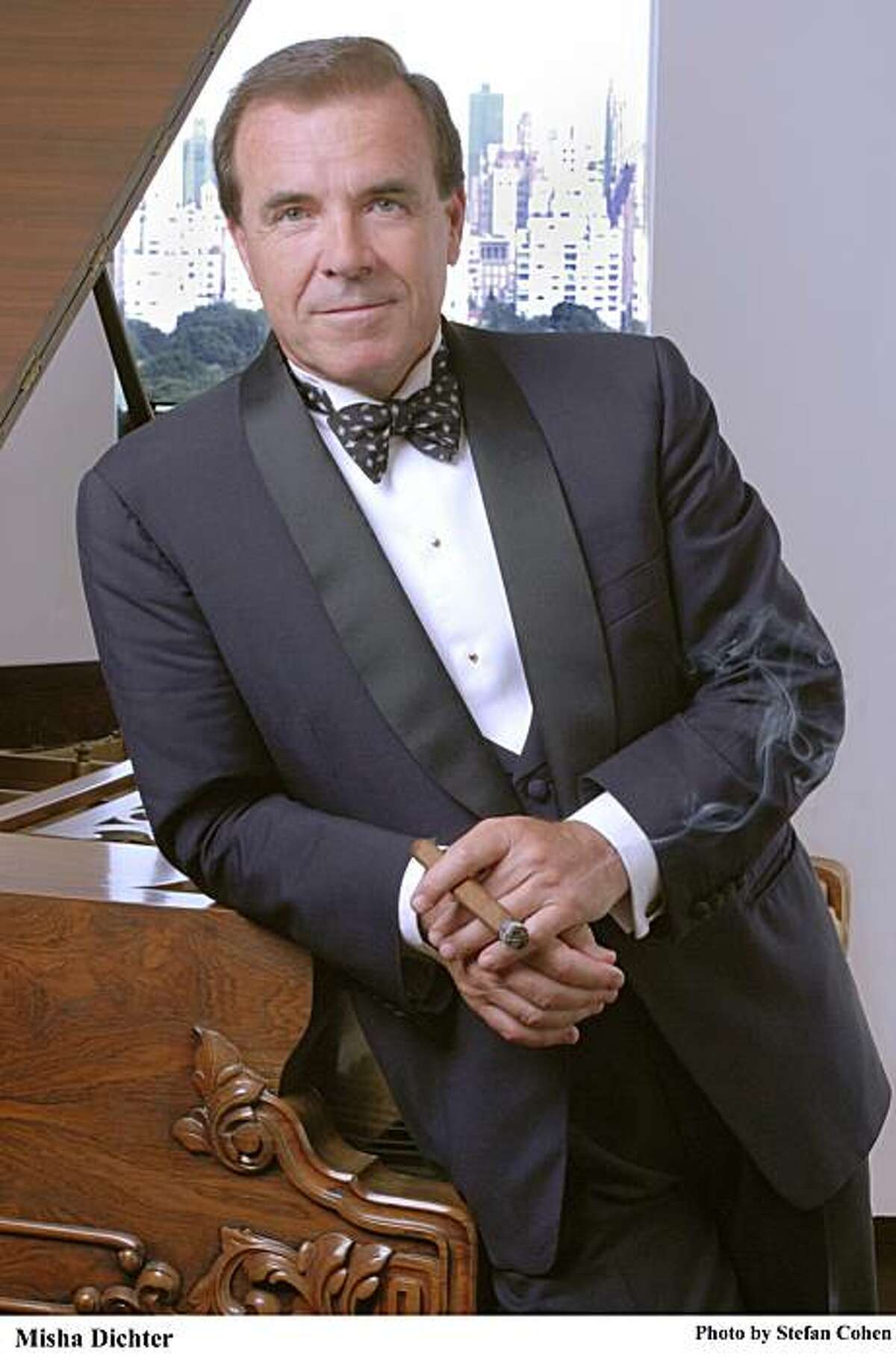 Man in a tuxedo leaning against a piano