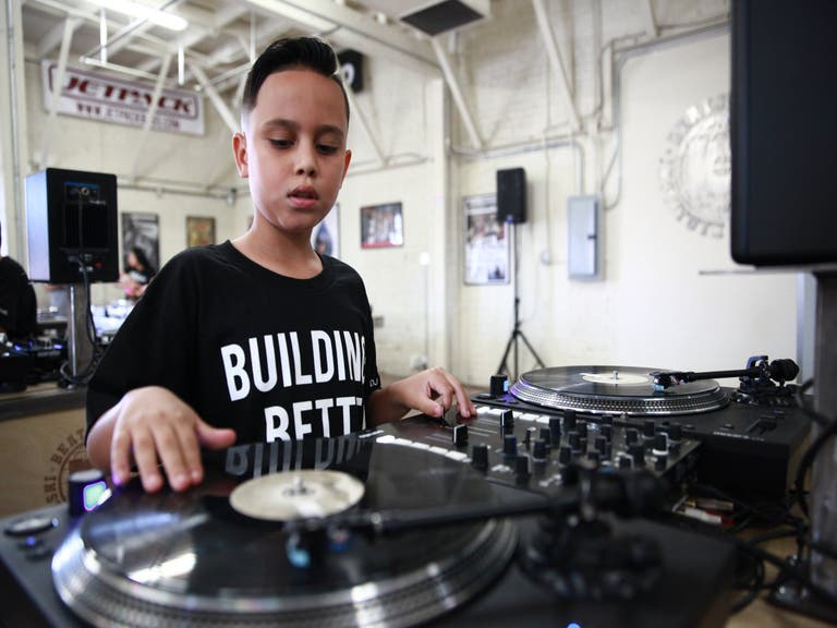 A young student learns to scratch at the Beat Junkie Institute of Sound