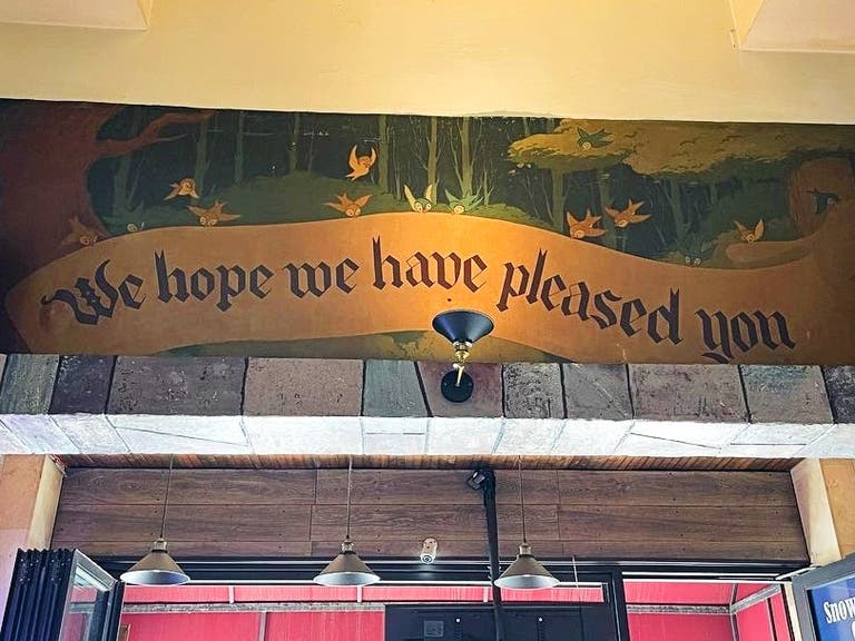 "We hope we have pleased you" mural at the Snow White Cafe