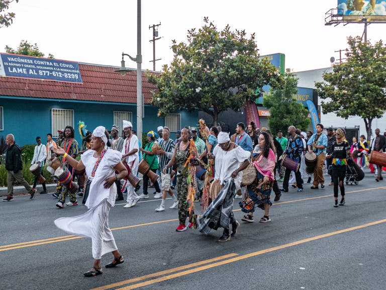 parade dancers and Drummers walking down Crenshaw Blvd to the Leimert Park Festival on June 25th, 2023