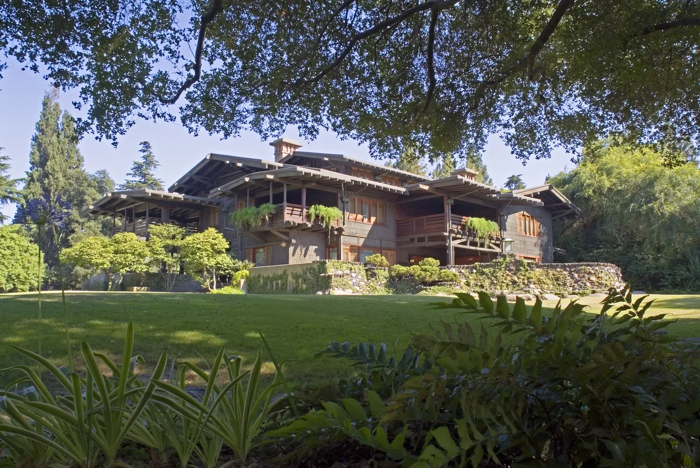 A brown craftsman home located in shaded greenery