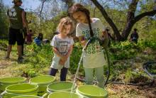 TreePeople two girls filling water buckets