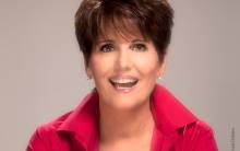 Lucie Arnaz, woman in red shirt smiling 