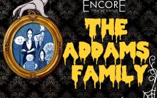 The Addams Family in bright yellow on black and gold wallpaper with a framed photo of the Addams Family and a white spider web in the corner